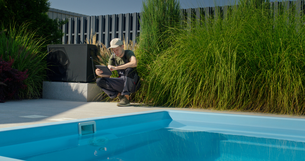 technician-working-by-pool-checking-tablet-while-surrounded-by-greenery.jpg